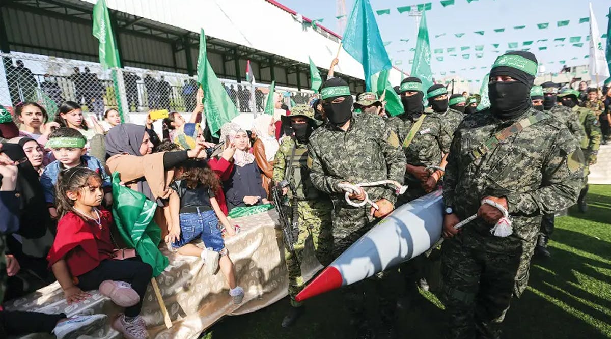 Hamas members carry a rocket as they march during an anti-Israel rally in Rafah