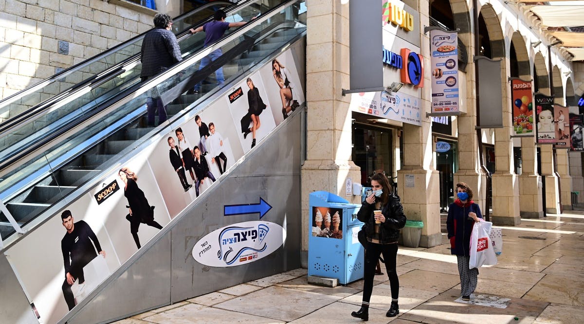 People walk in a mall in Rosh Pina, ahead of its wider reopening to the public