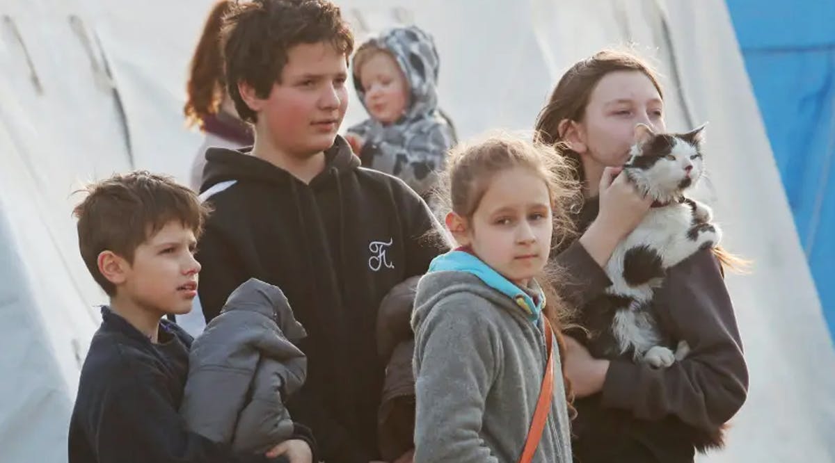 Children and a cat at a temporary accommodation center for evacuees