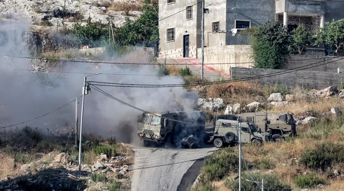 Smoke billows from the aftermath of the detonation of a Palestinian explosive charge on an Israeli armoured vehicle during an Israeli army raid in Jenin in the West Bank