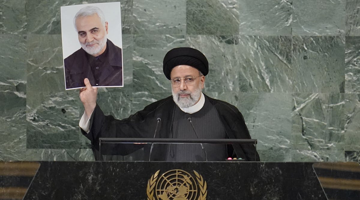 President of Iran Ebrahim Raisi holds up a photo of assassinated Iranian Gen. Qassem Soleimani