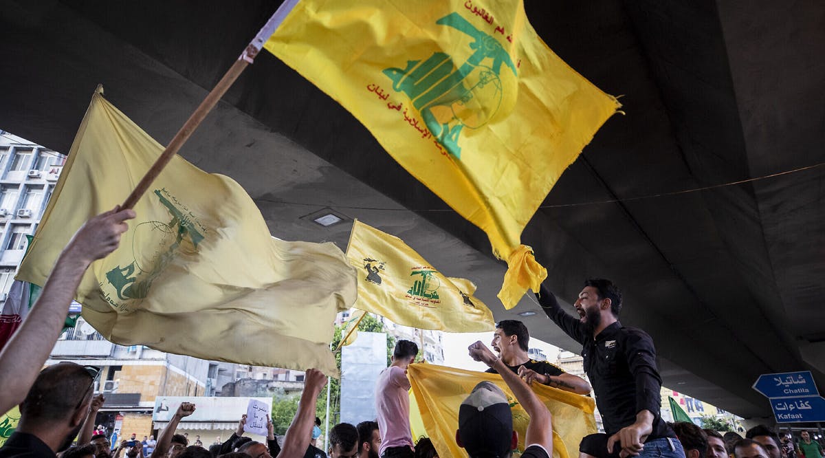 Hezbollah and Amal supporters wave Hezbollah and Iranian flags