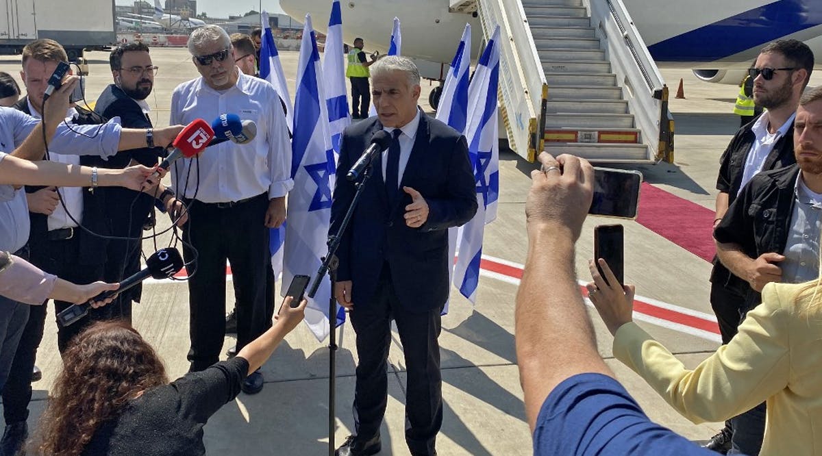 Prime Minister Yair Lapid speaks to the press ahead of his first overseas trip as PM, to Paris, at Ben Gurion Airport