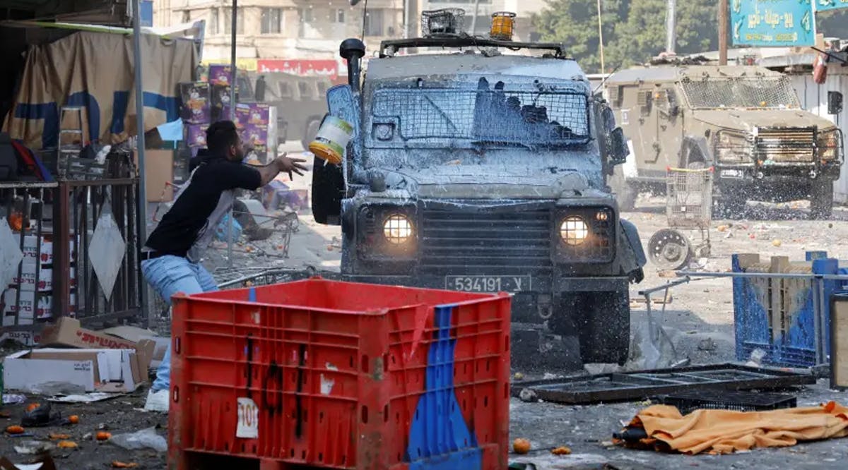 Palestinians clash with Israeli forces during a raid in Nablus in the West Bank