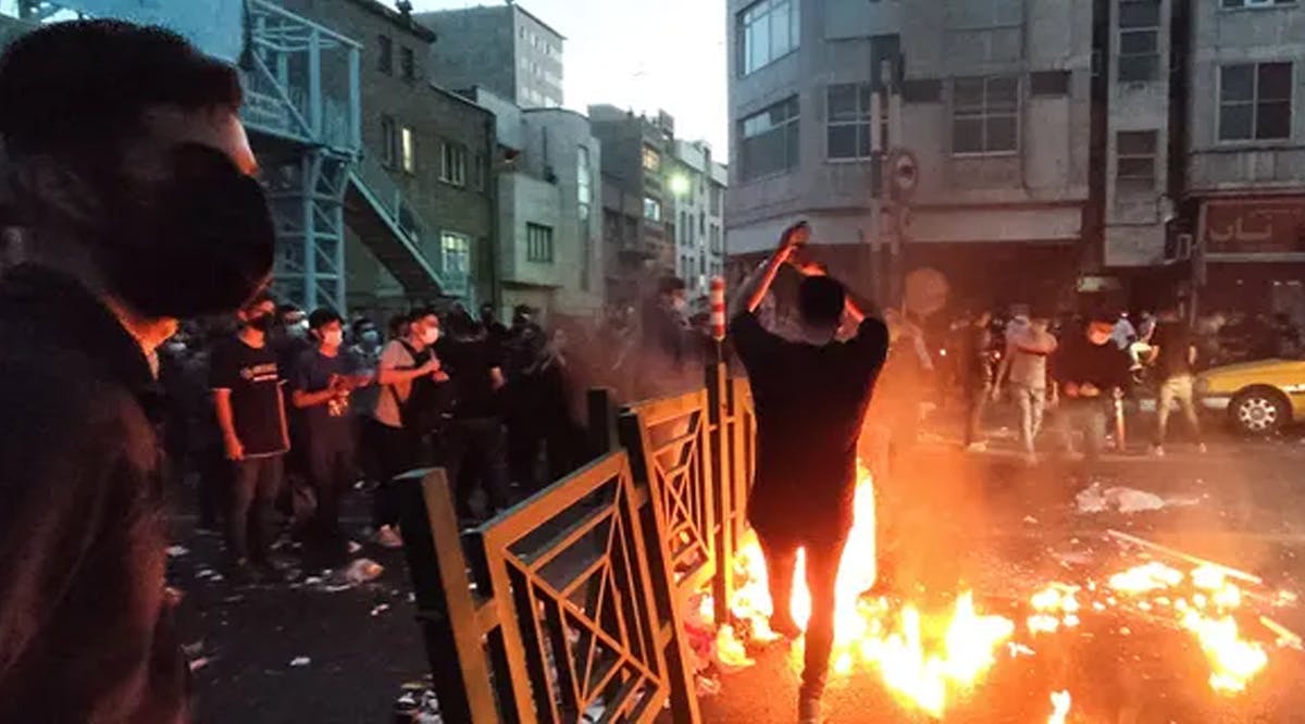 People light a fire during a protest in Tehran, Iran