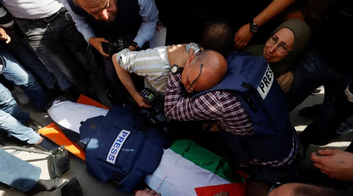 Journalists mourn next to the body of Al Jazeera reporter Shireen Abu Akleh