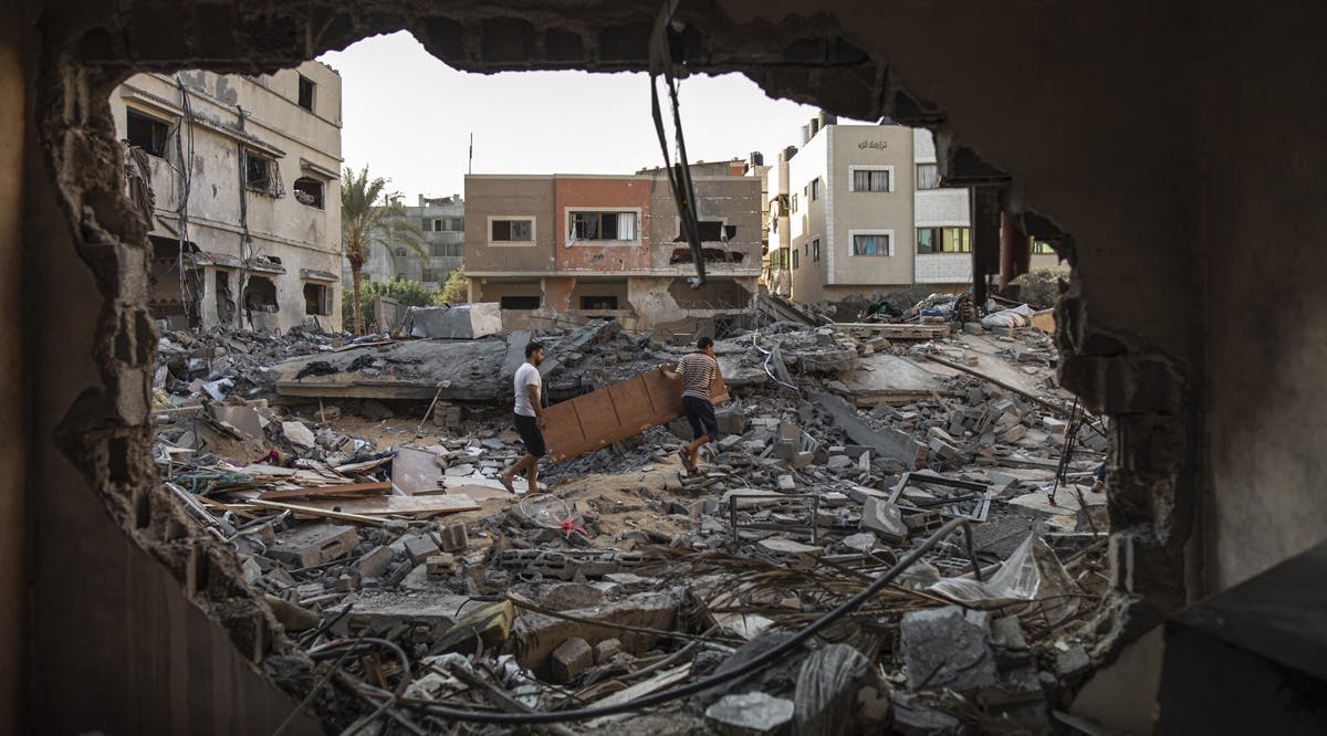 Palestinians inspect their house which was hit by an Israeli airstrike in Gaza City