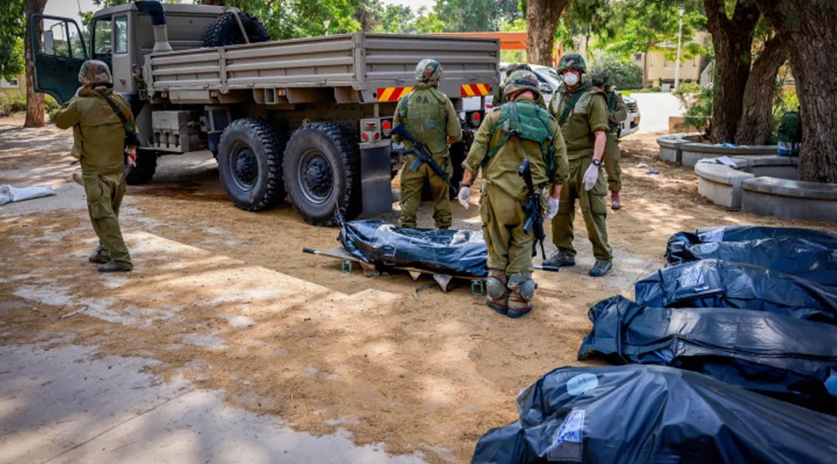 Israeli soldiers remove bodies in Kibbutz Kfar Aza, near the border with Gaza, in southern Israel
