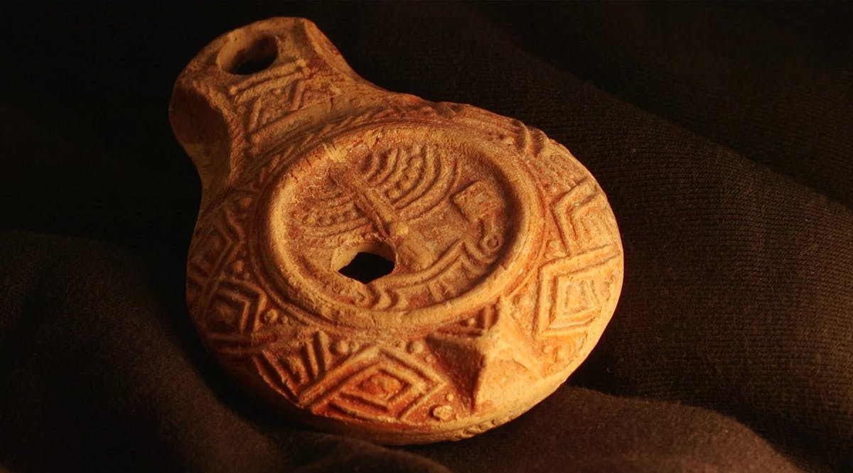 Rare, 1,700-year-old oil lamp with Temple menorah decoration found in Jerusalem, in an image released on December 26, 2024. (Emil Aladjem/Israel Antiquities Authority)