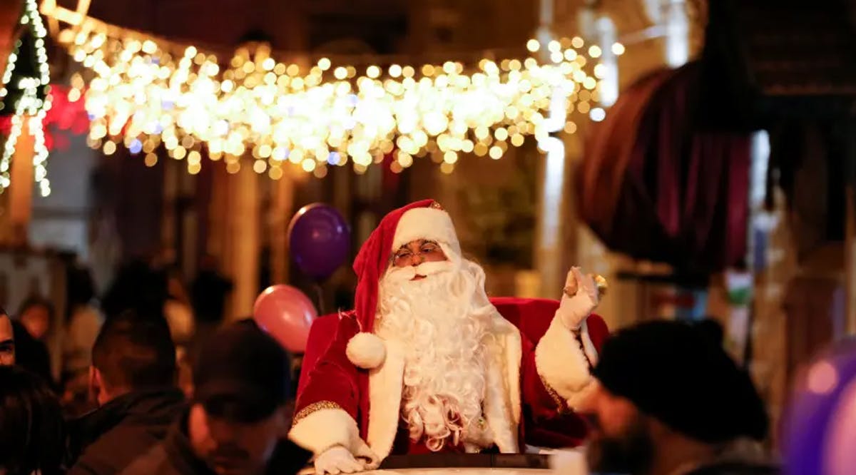 A Palestinian dressed as Santa gestures during a celebration in Bethlehem, in the West Bank