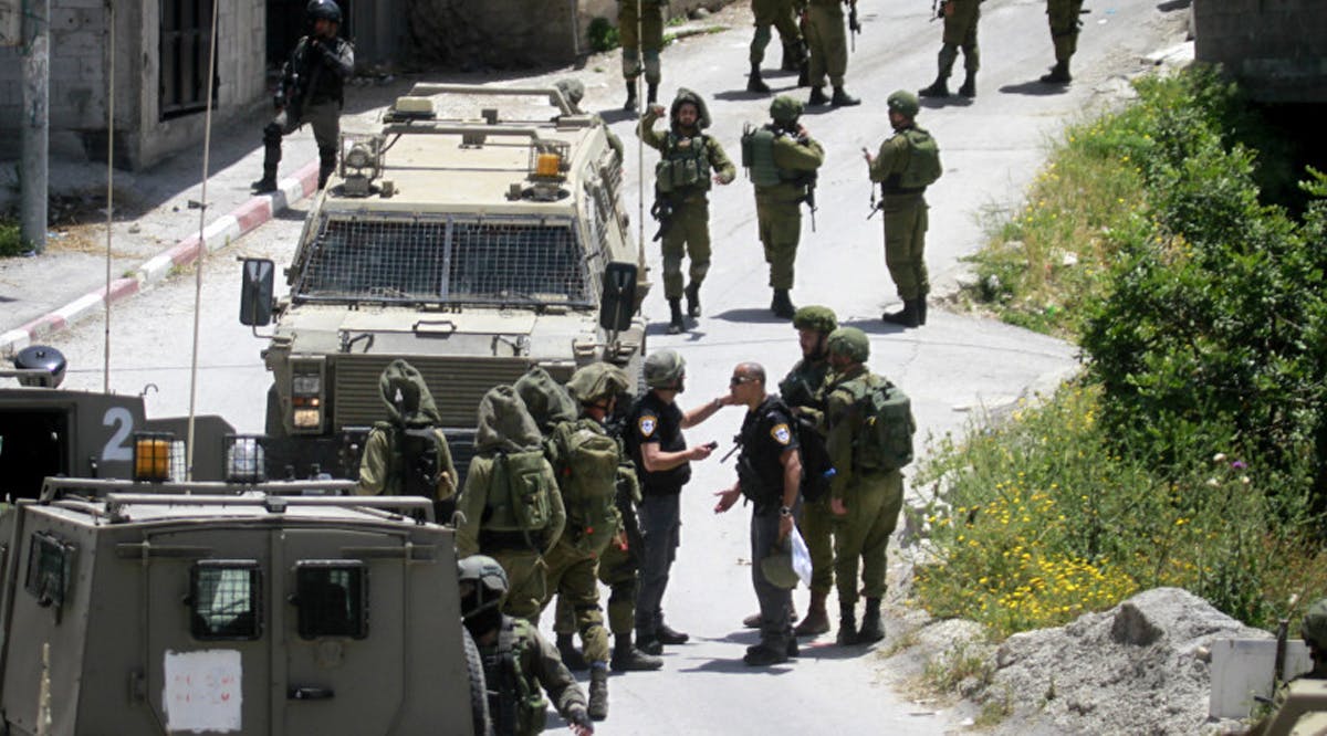 Israeli soldiers detain Palestinians in the village of Yabad, near the West Bank city of Jenin