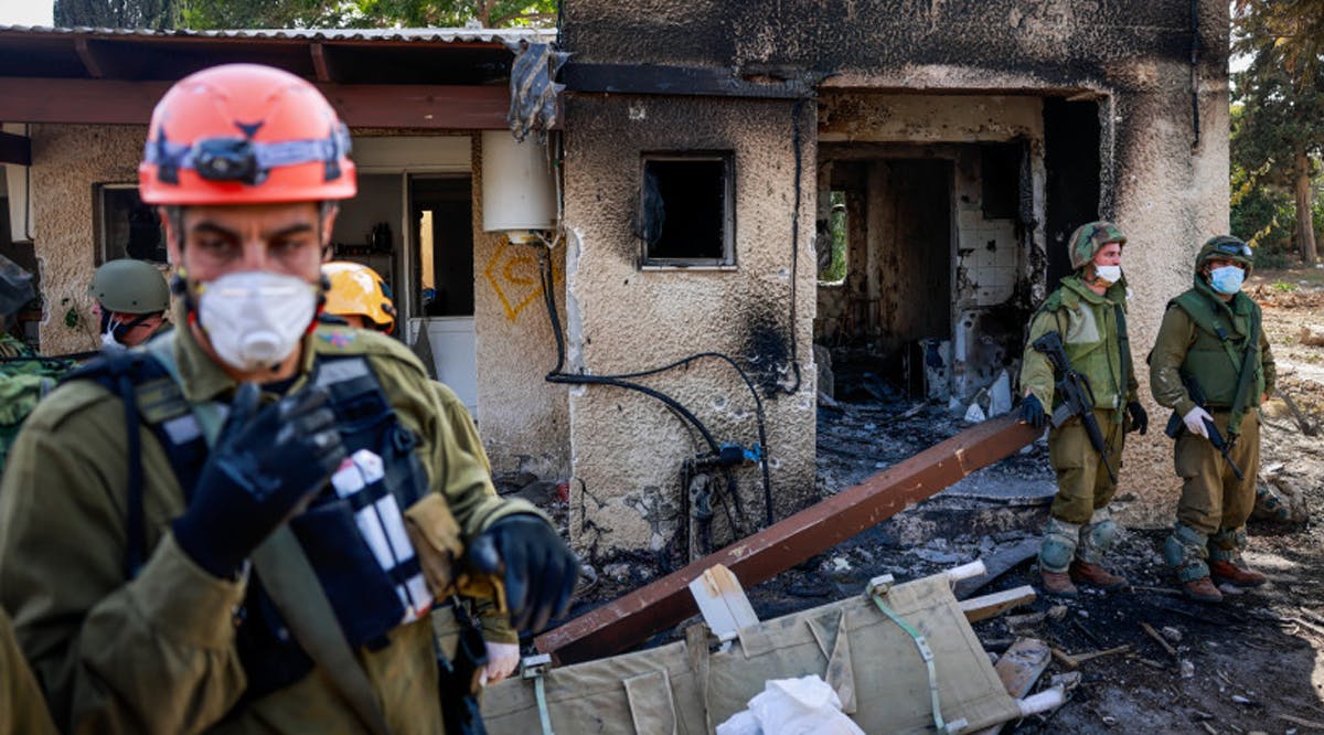 Israeli soldiers around the destruction caused by Hamas Militants in Kibbutz Kfar Aza, near the Israeli-Gaza border, in southern Israel