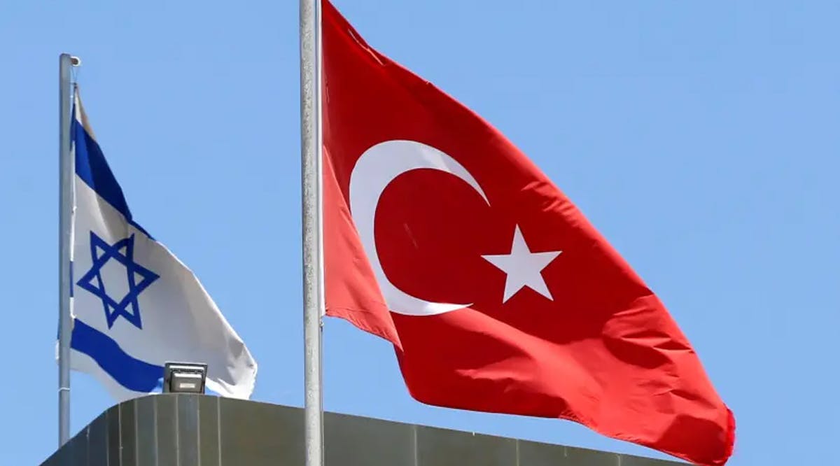 A Turkish flag flutters atop the Turkish embassy as an Israeli flag is seen nearby, in Tel Aviv