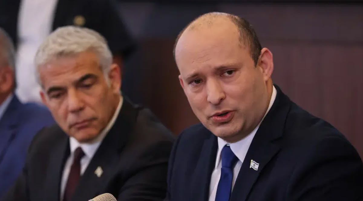 Israeli Prime Minister Naftali Bennett sits next to alternate Prime Minister and Foreign Minister Yair Lapid