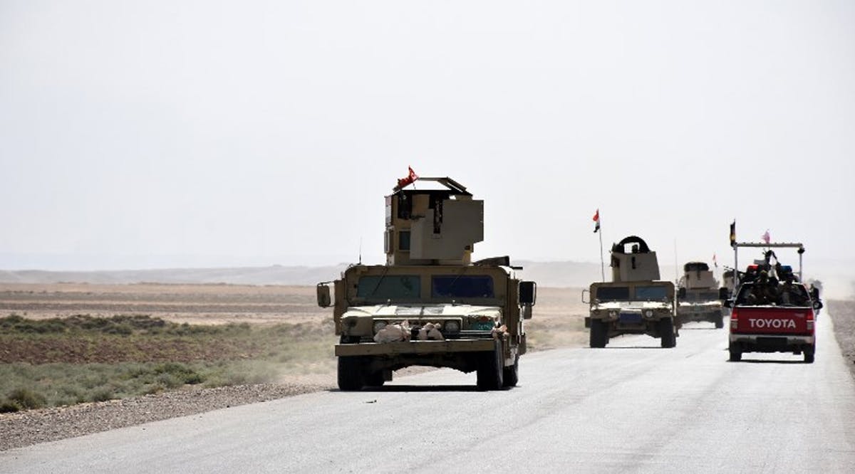 Iraqi army reinforcements drive down a road, linking Hawija to Kirkuk