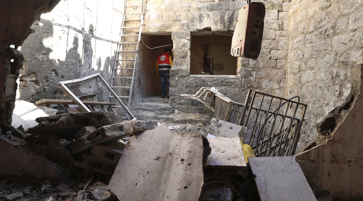 A medic inspects the site where three Palestinians were killed