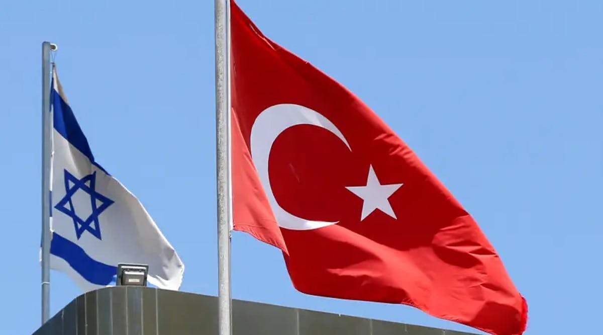 A Turkish flag flutters atop the Turkish embassy as an Israeli flag is seen nearby, in Tel Aviv