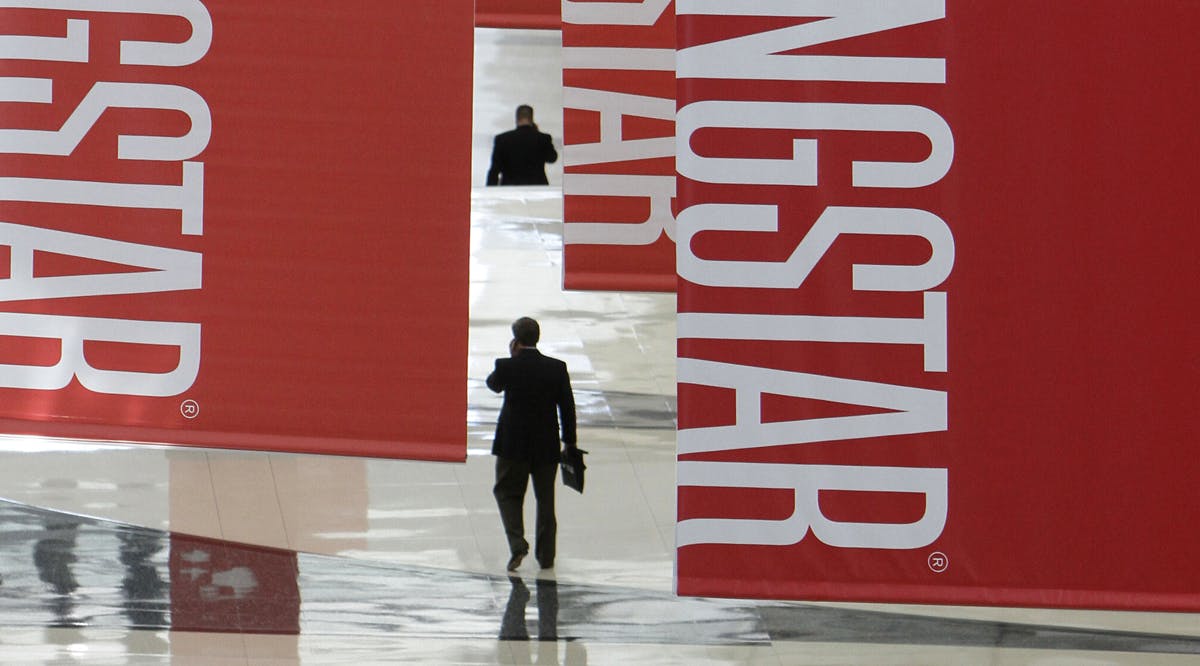 Attendees of a Morningstar investment conference walk beneath banners at the McCormick Center in Chicago