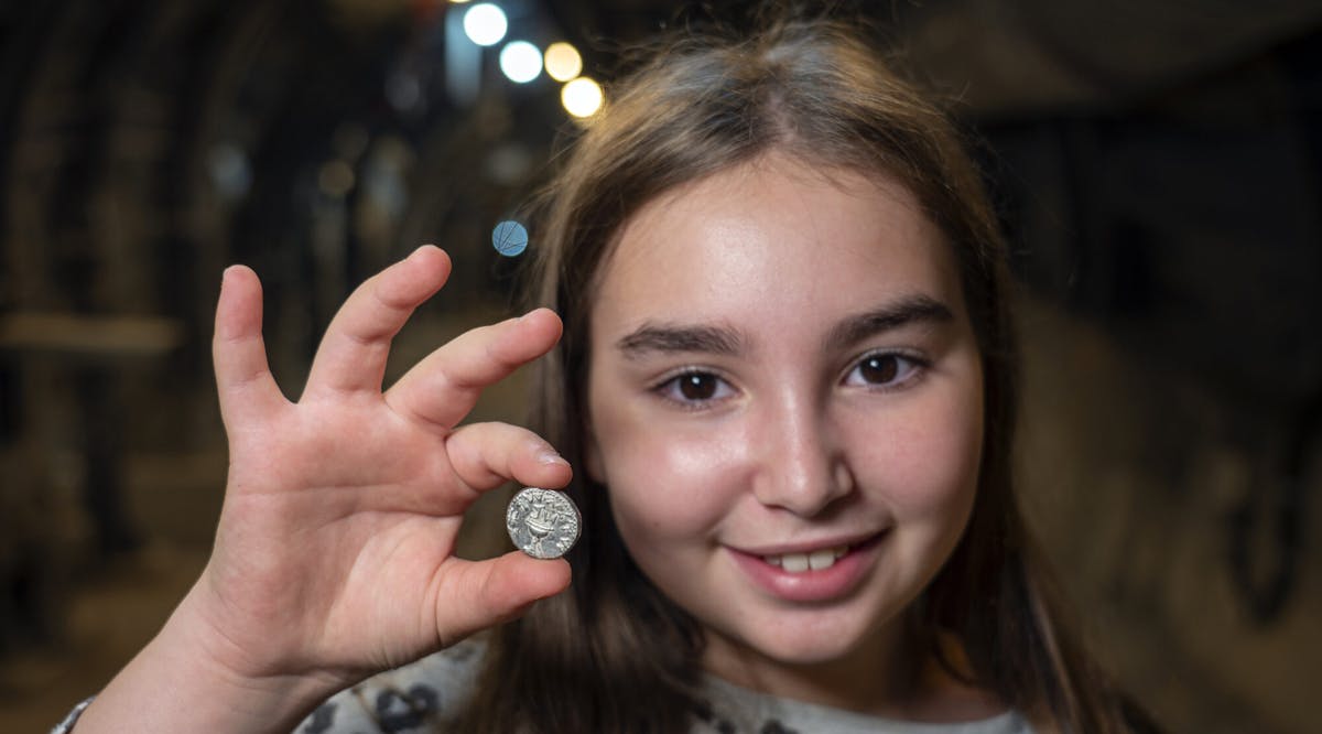 Liel Krutokop holds the coin she found in Jerusalem