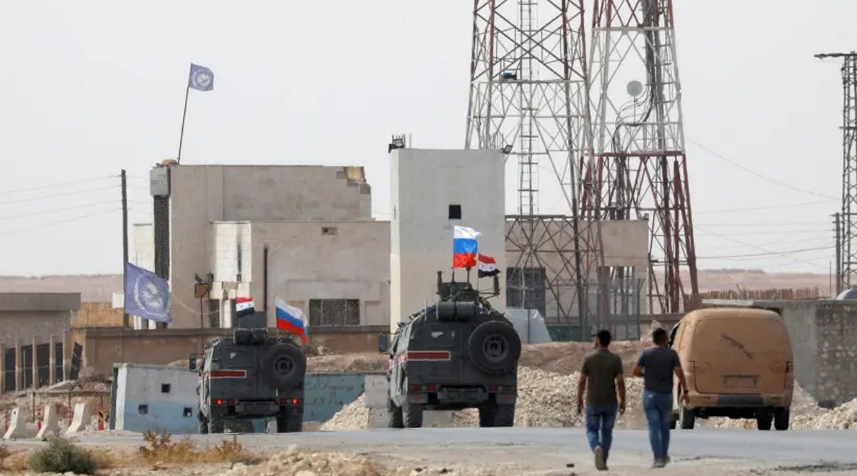 National flags flutter on military vehicles near Manbij, Syria