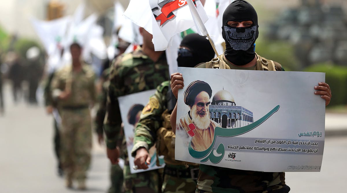 Iran-linked fighters with a portrait of Iran's late leader Ayatollah Khomeini in Baghdad, Iraq