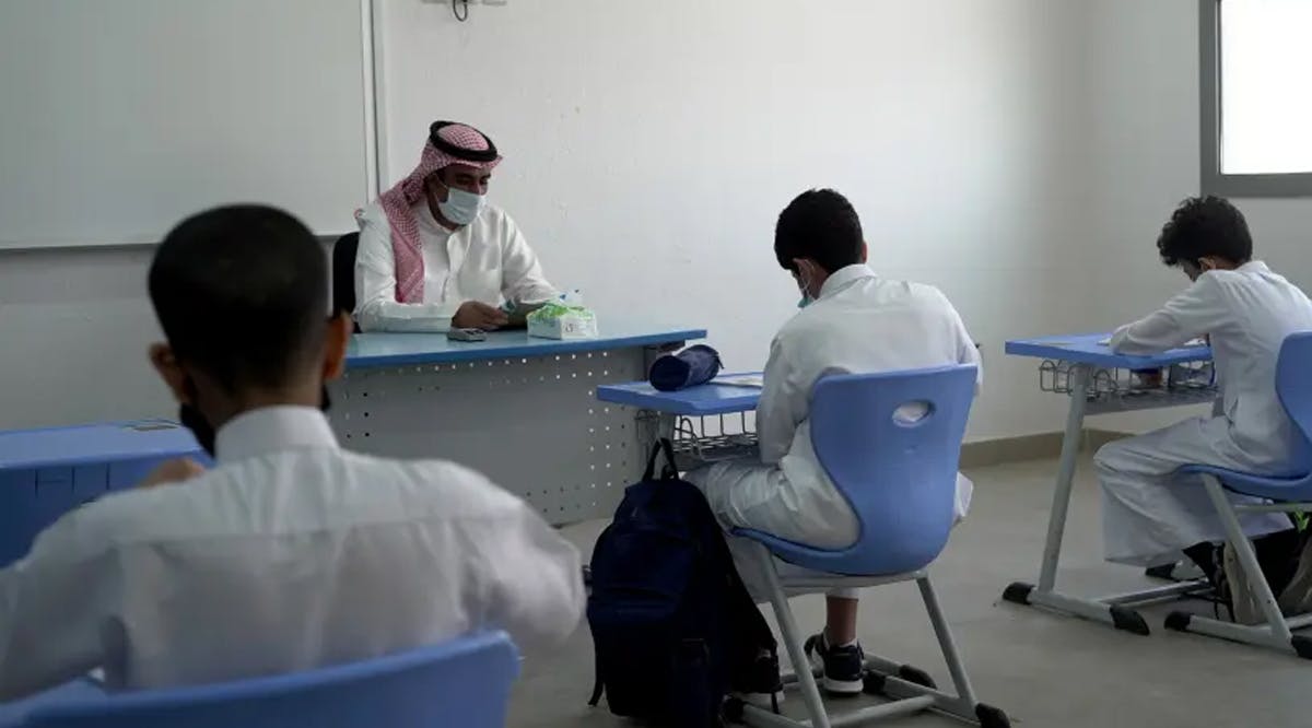 A Saudi teacher wearing a face mask teaches a class at a school in Riyadh, Saudi Arabia