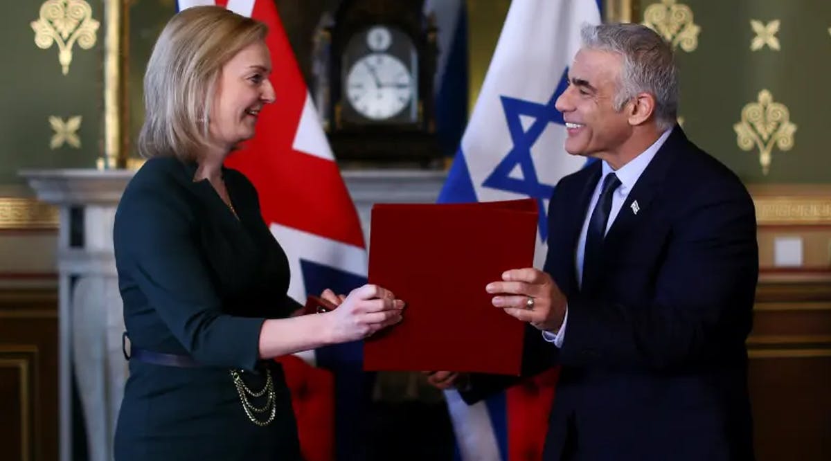 Britain's Foreign Secretary Liz Truss and Israeli Foreign Minister Yair Lapid exchange documents after signing a memorandum of understanding at Britain's Foreign Commonwealth & Development Office in London