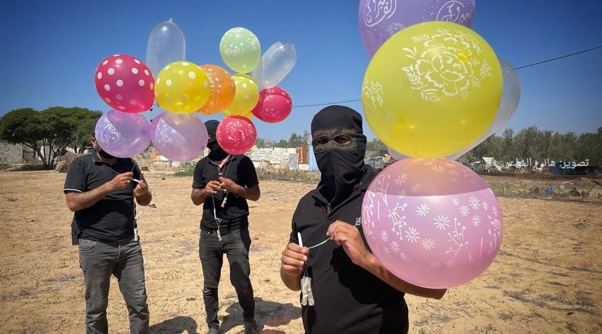 Masked Gazans prepare to launch fire-sparking balloons toward Israel in the Gaza Strip