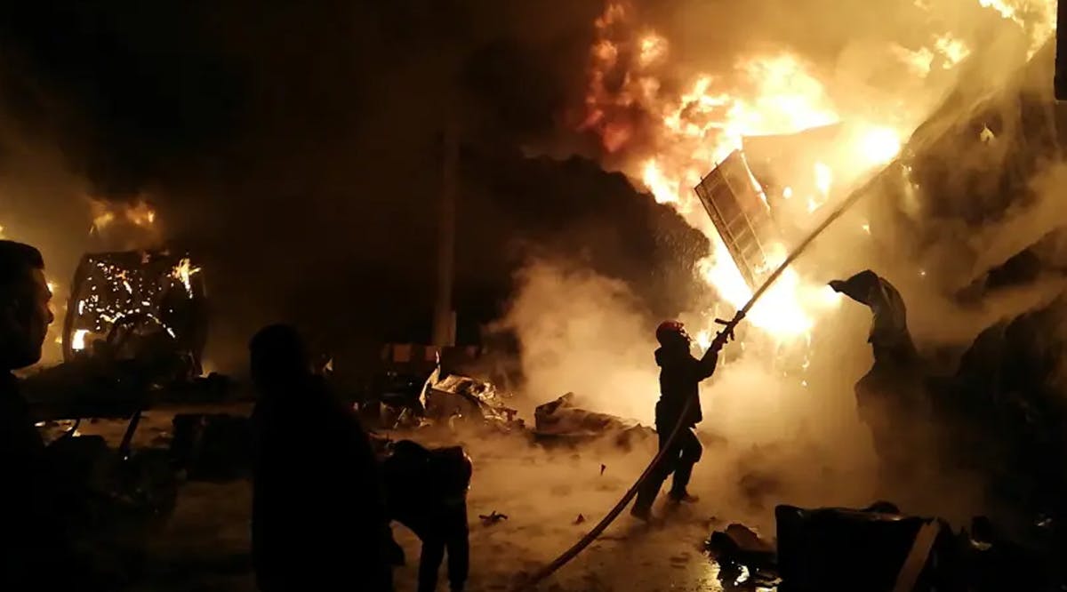 A Firefighter douses flames after Syrian state media reported an alleged Israeli missile attack in a container storage area, at Syrian port of Latakia, Syria