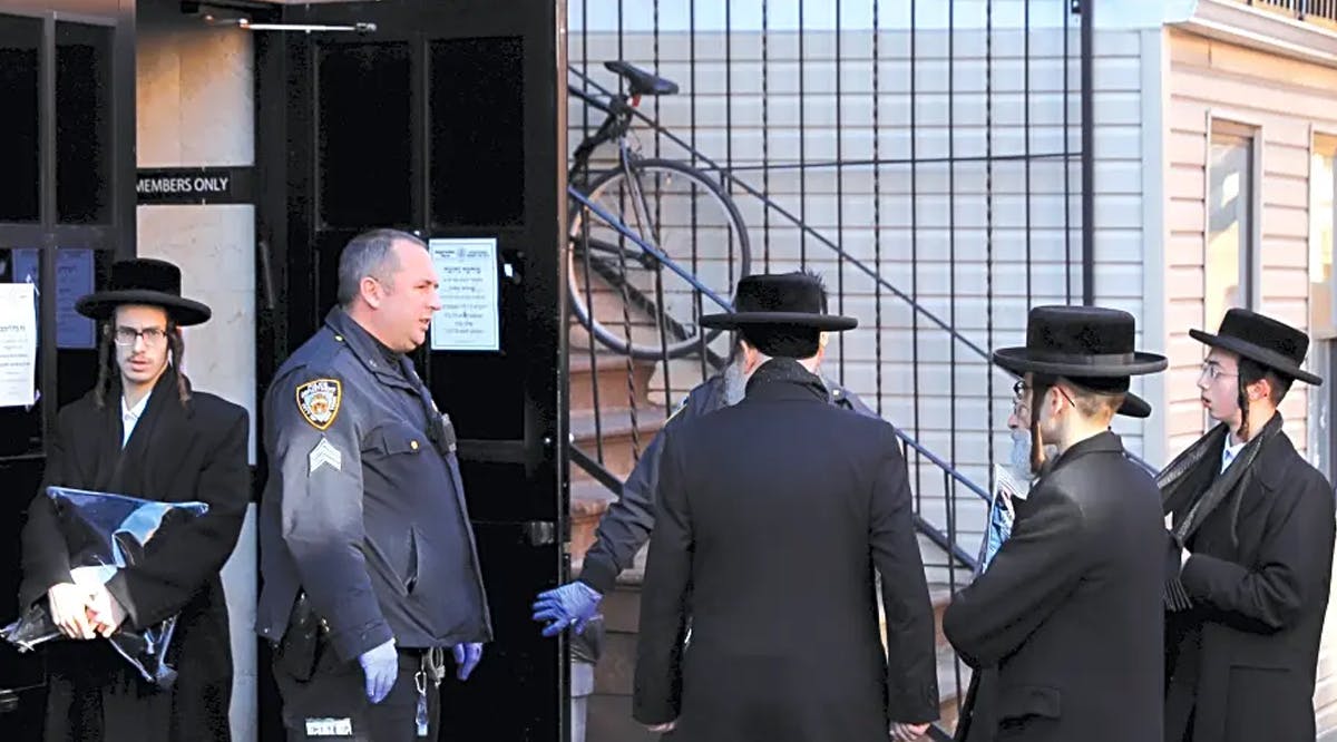 Hasidic Jewish men gather outside of a synagogue