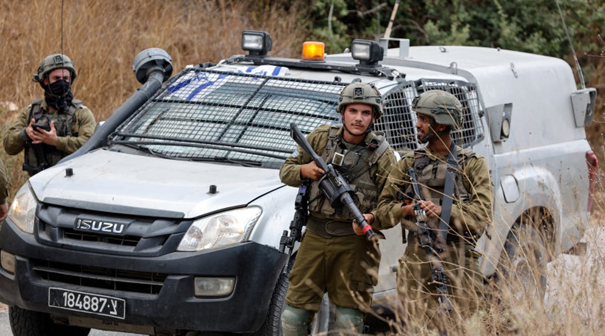 Israeli soldiers stand near the scene where, according to the IDF, a Palestinian had thrown a grenade and shot at soldiers who returned fire at him, near Neve Tzuf, in the West Bank