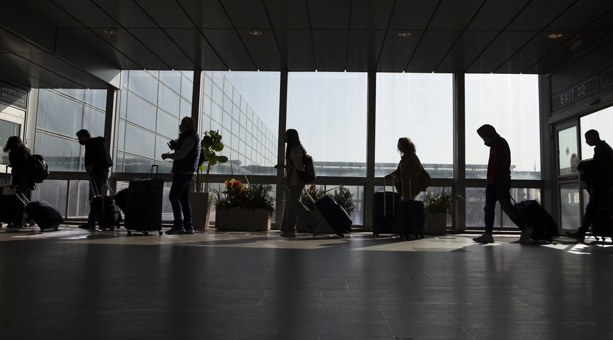 Travelers walk with their luggage in Ben Gurion Airport near Tel Aviv