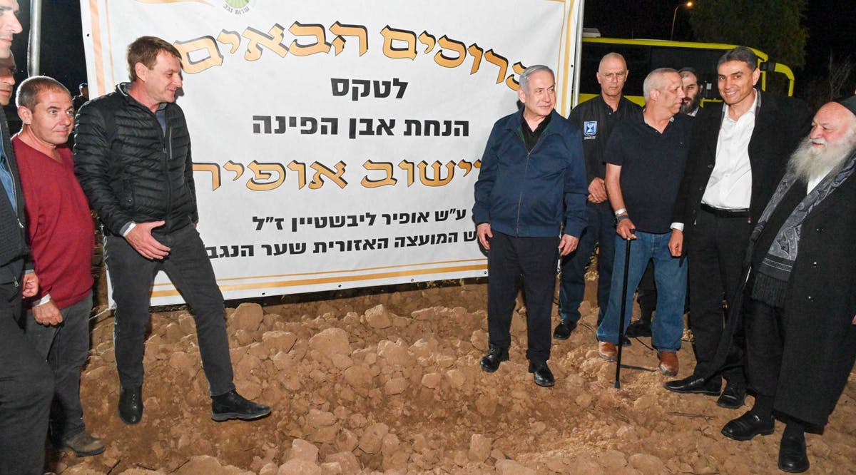 Prime Minister Benjamin Netanyahu, center, lays the foundation stone for a new community, Ofir, as he meets with municipal leaders of communities close to the Gaza Strip