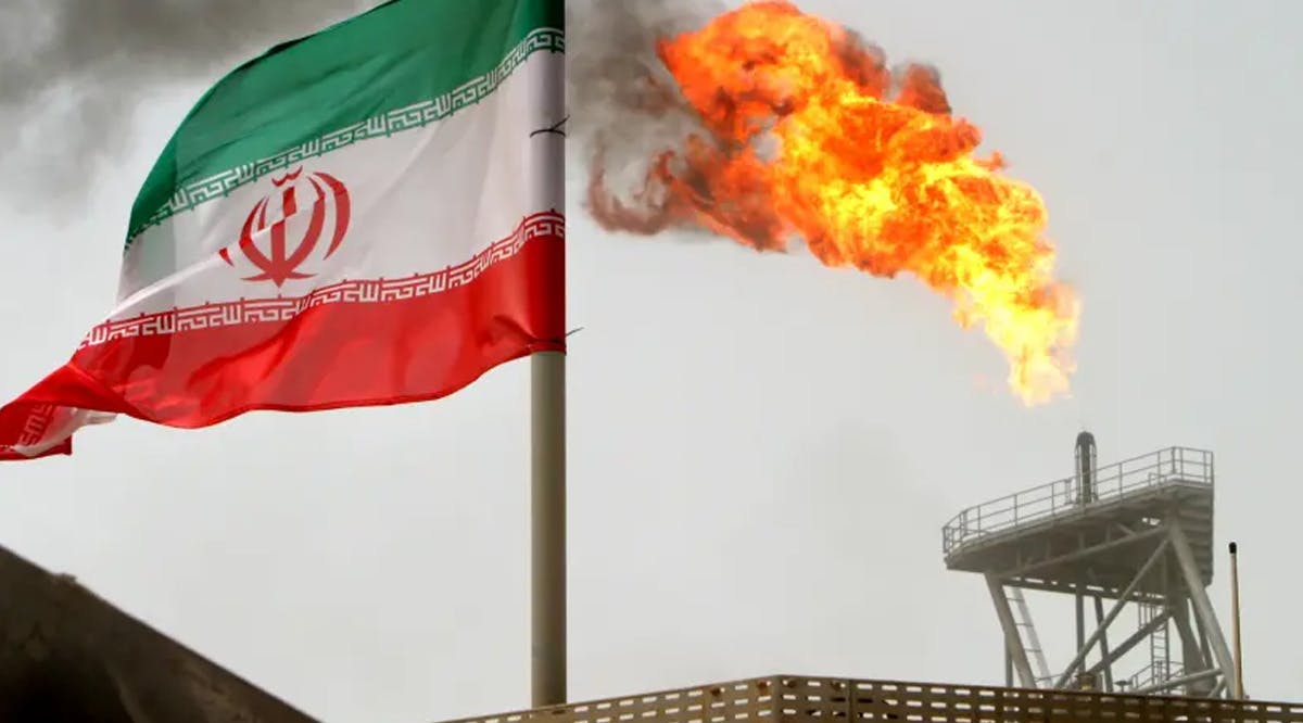A gas flare on an oil production platform is seen alongside an Iranian flag in the Gulf