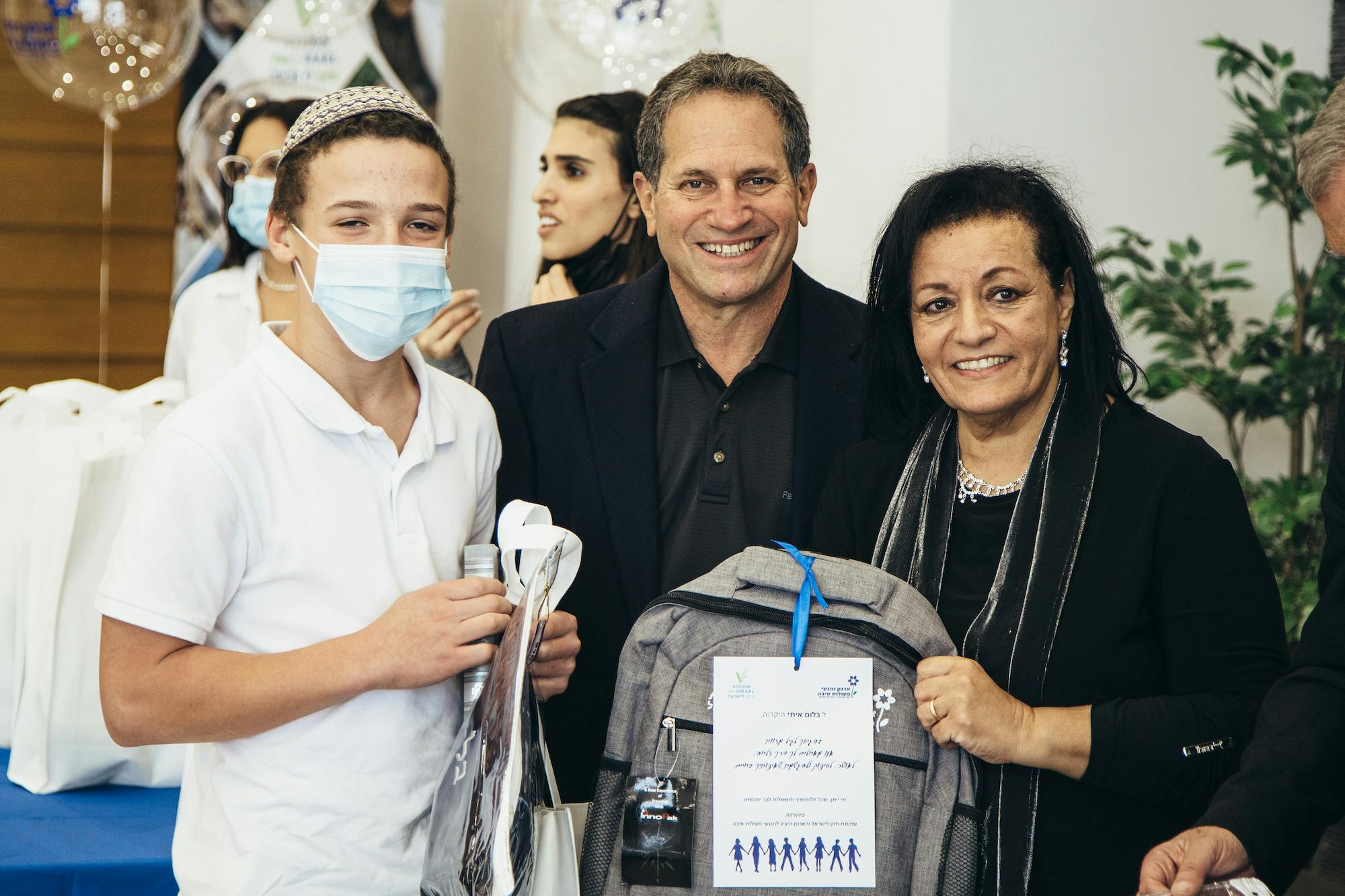 Barry and Batya gifting a backpack 