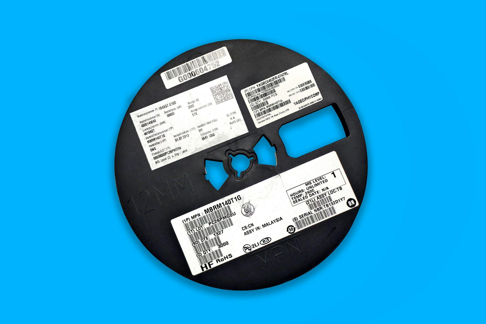 Une bobine CMS avec de nombreuses étiquettes et codes sur un fond bleu