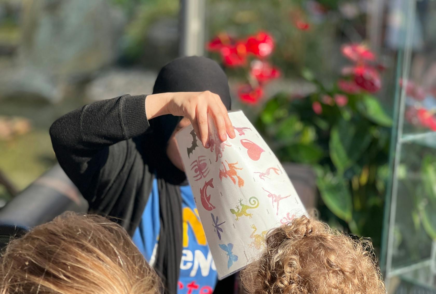 A child animator with a hijab holds the selection of motifs for a child.