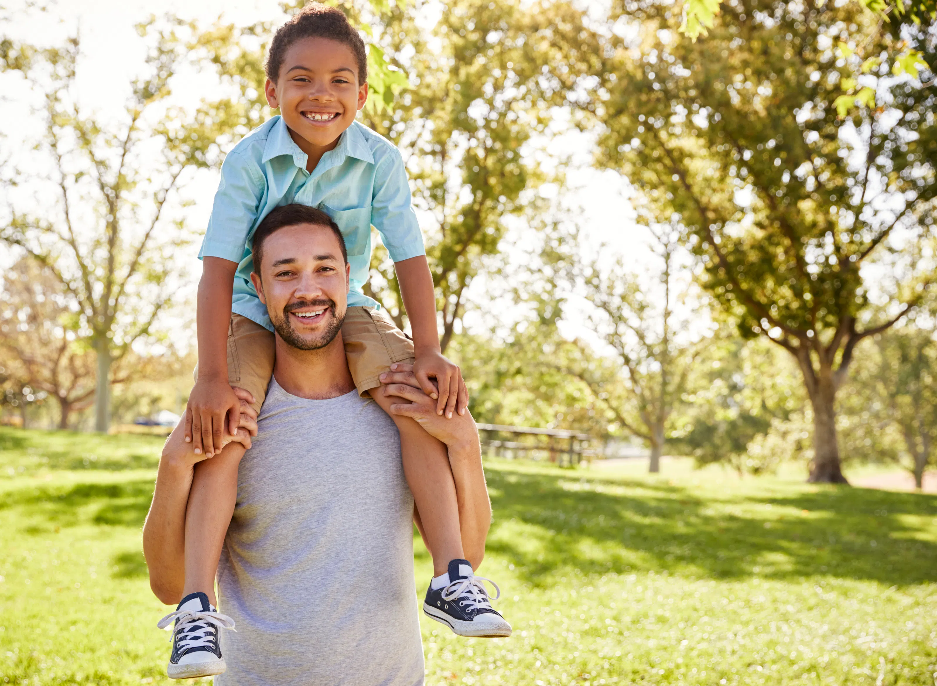 A father carrying his son on his shoulders outdoors