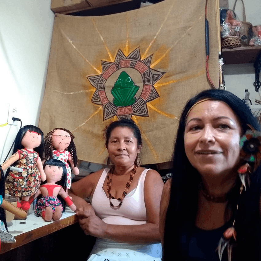 Luakam (to the left) and her Anaty dolls, next to teacher Marise (Pararipe), President of the Indigenous Association of the Maracanã Indian Village. Rio de Janeiro, RJ, 2021.