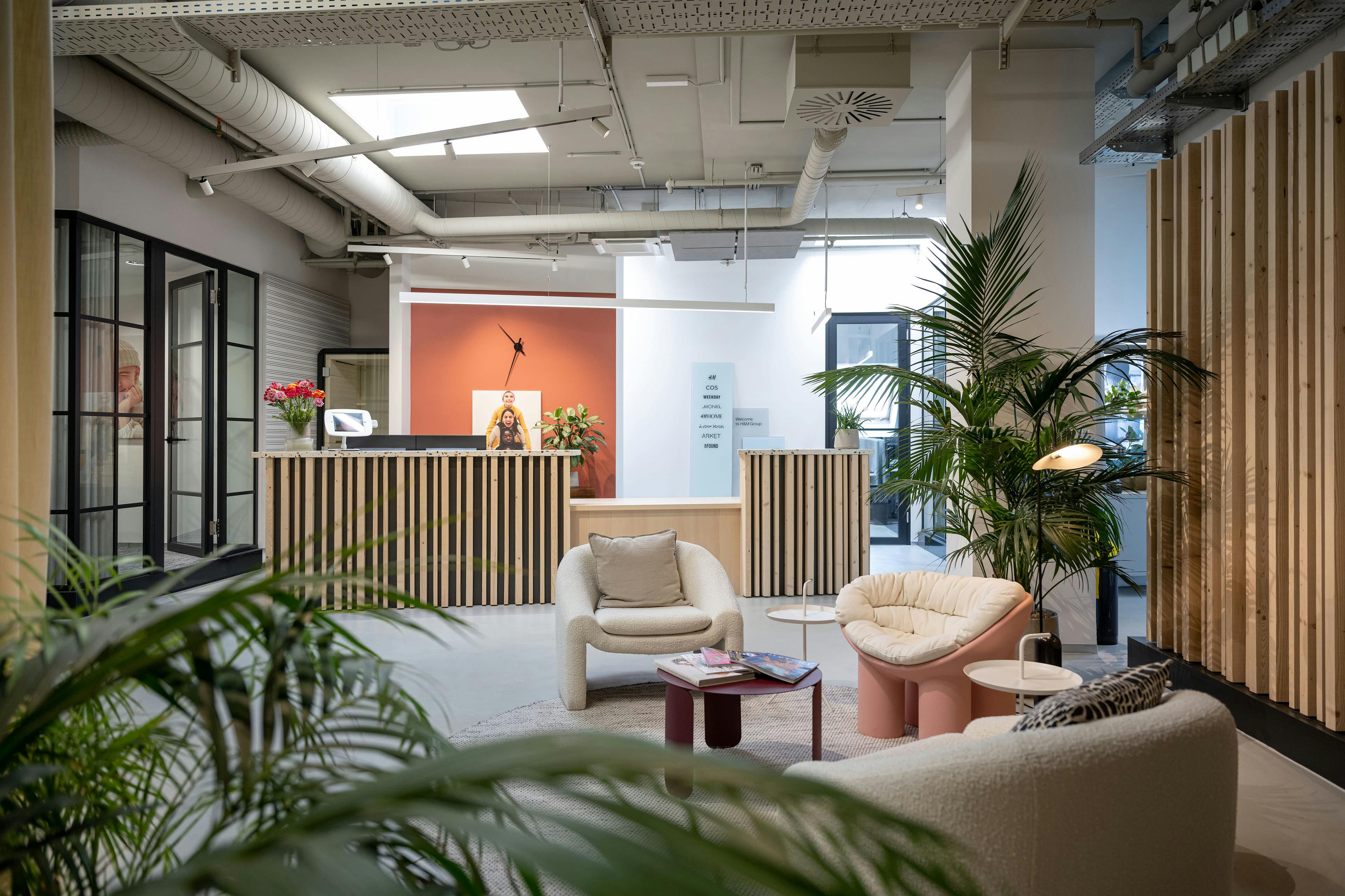 Heller freundlicher Empfangsraum der H&M Zentrale in Wien. Moderne, skandinavische Innenarchitektur und angenehme Sitzgelegenheiten.