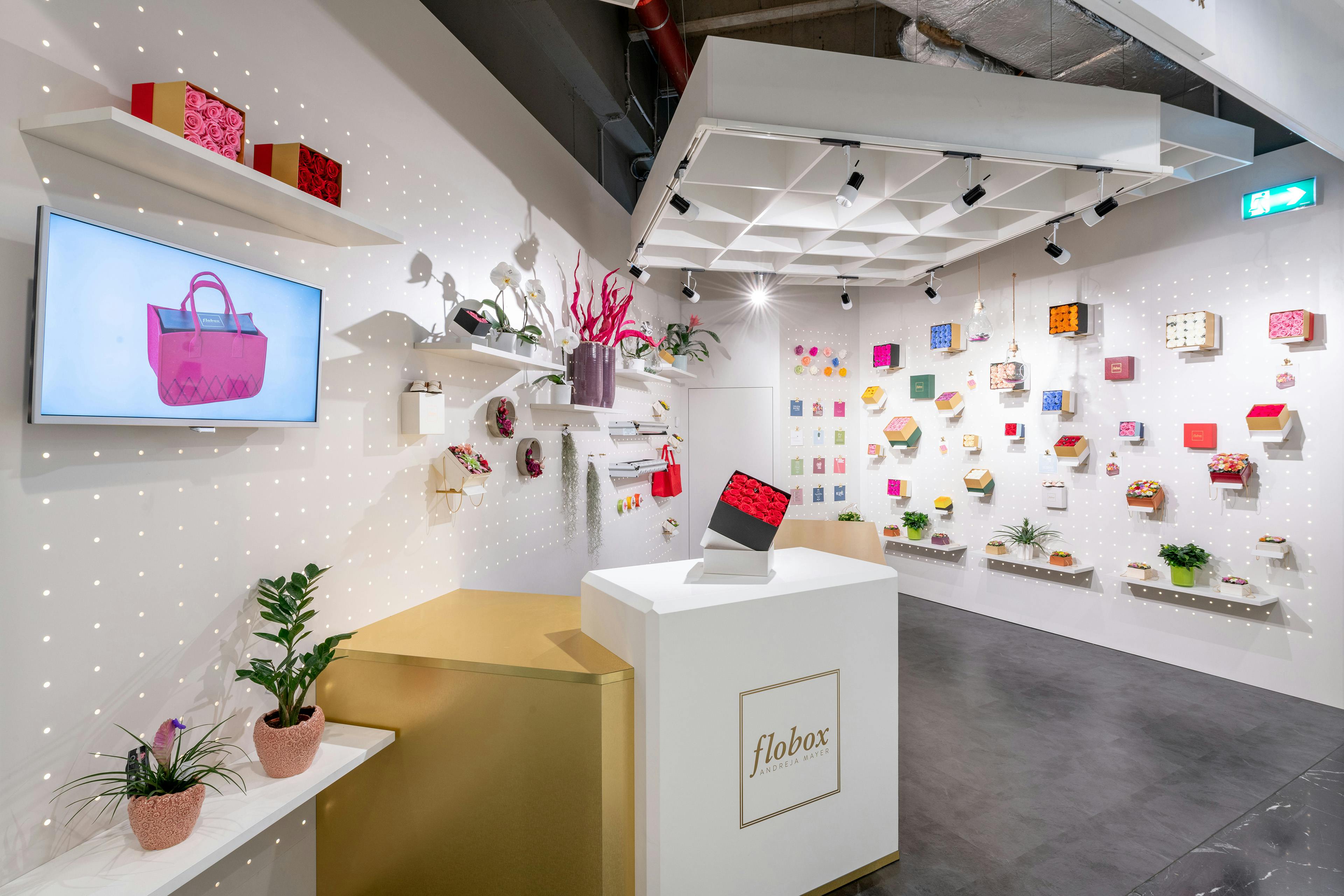 Die Verkaufsfläche mit einem Regalsystem, an dem Blumen-Boxen hängen.