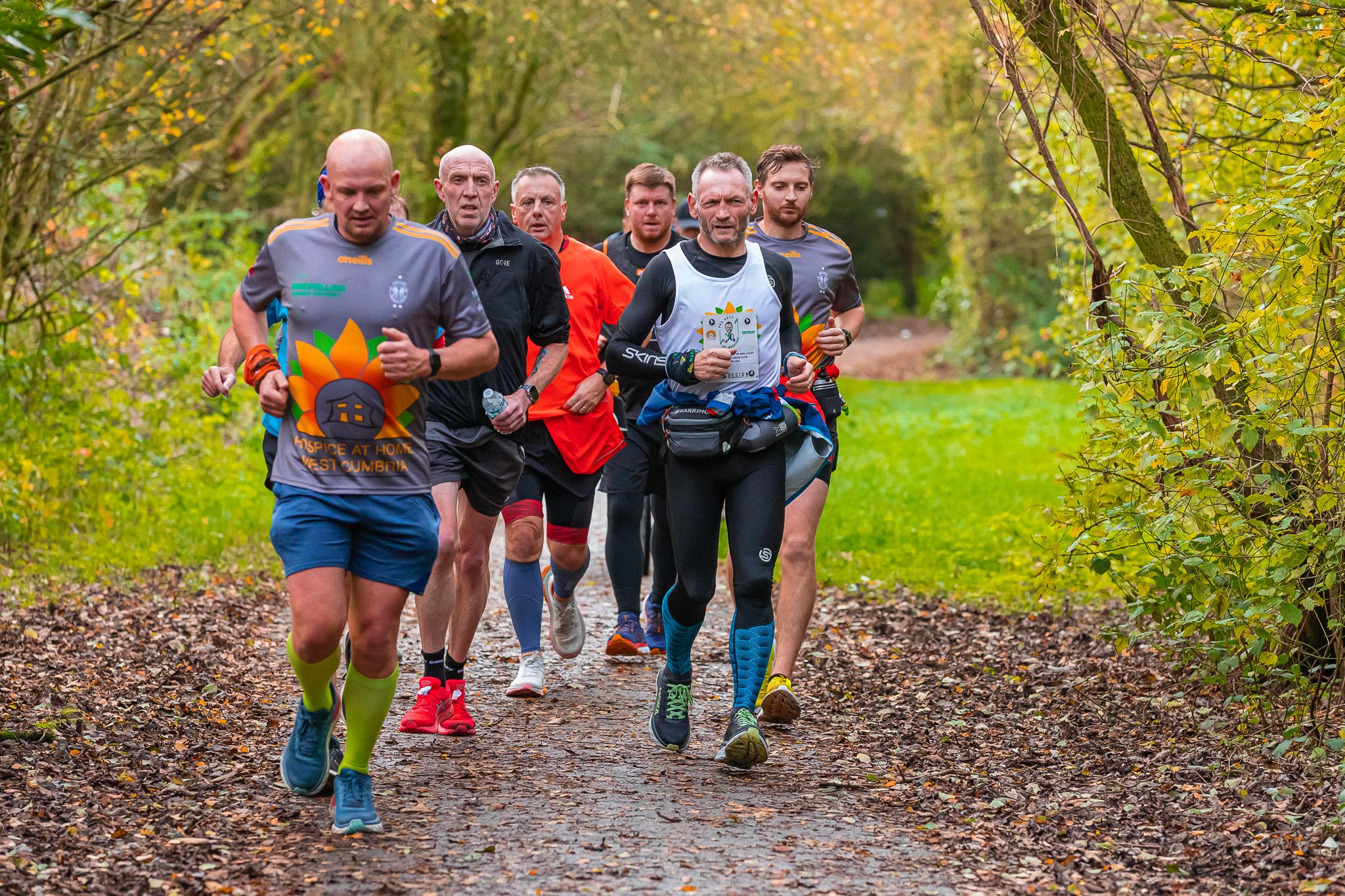 Gary running on a forest trail with a group.