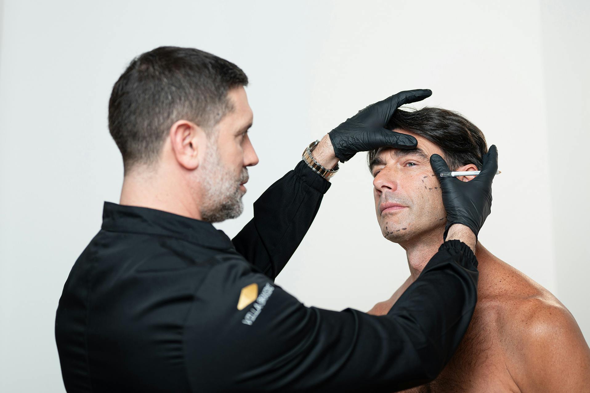 Il Dott. Ludovico Palla esegue marcature facciali su un paziente prima di un trattamento estetico presso Villa Brasini Beauty Clinic