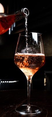 vino rosa cayendo en una copa 