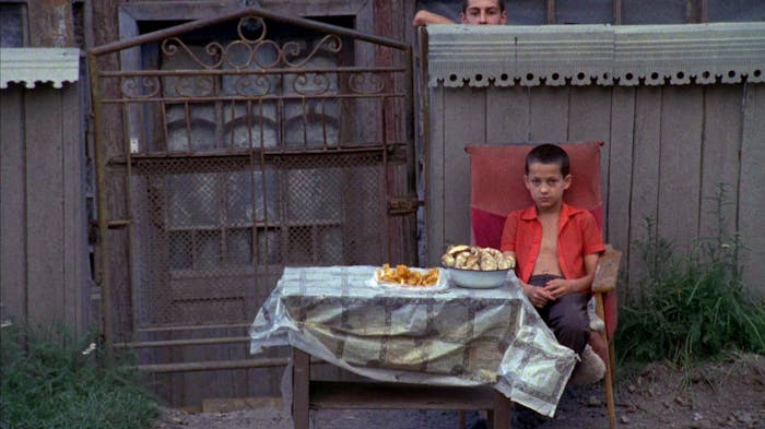 Young boy sits as a table outisde