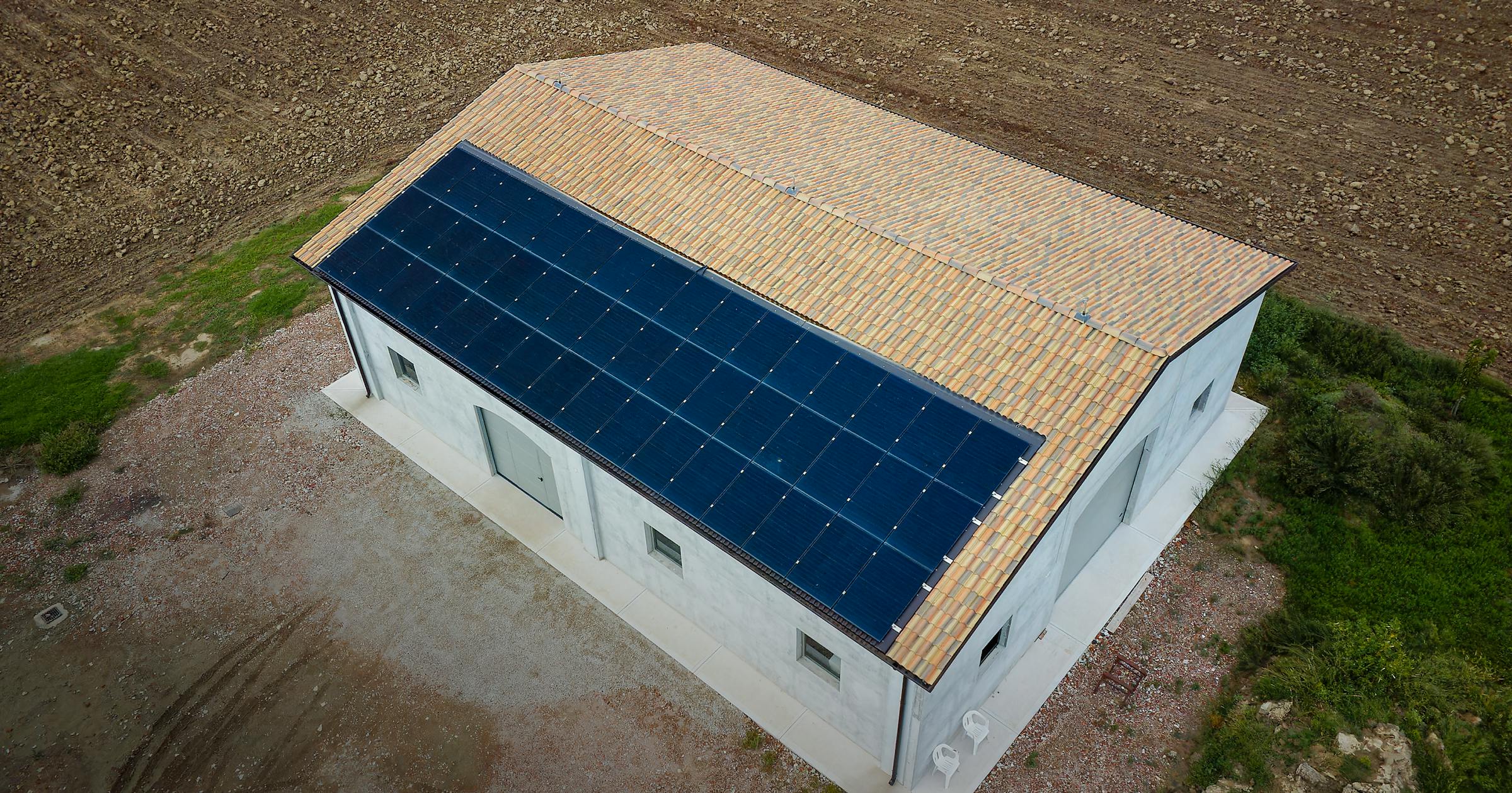 A colpo d’occhio sembra un impianto unico, ma la stringatura e la divisione dei sistemi lo rendono di fatto un progetto gemello, con due impianti indipendenti. Si tratta di un capannone situato a Mortizzuolo, una ricostruzione da terremoto curata da SEC Costruzioni che ora fornisce energia rinnovabile a due abitazioni.
