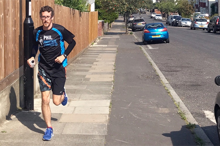 Man wearing a Prostate Cancer UK shirt running on road in the sunshine