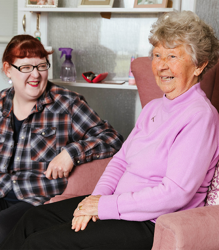 Two women together smiling.