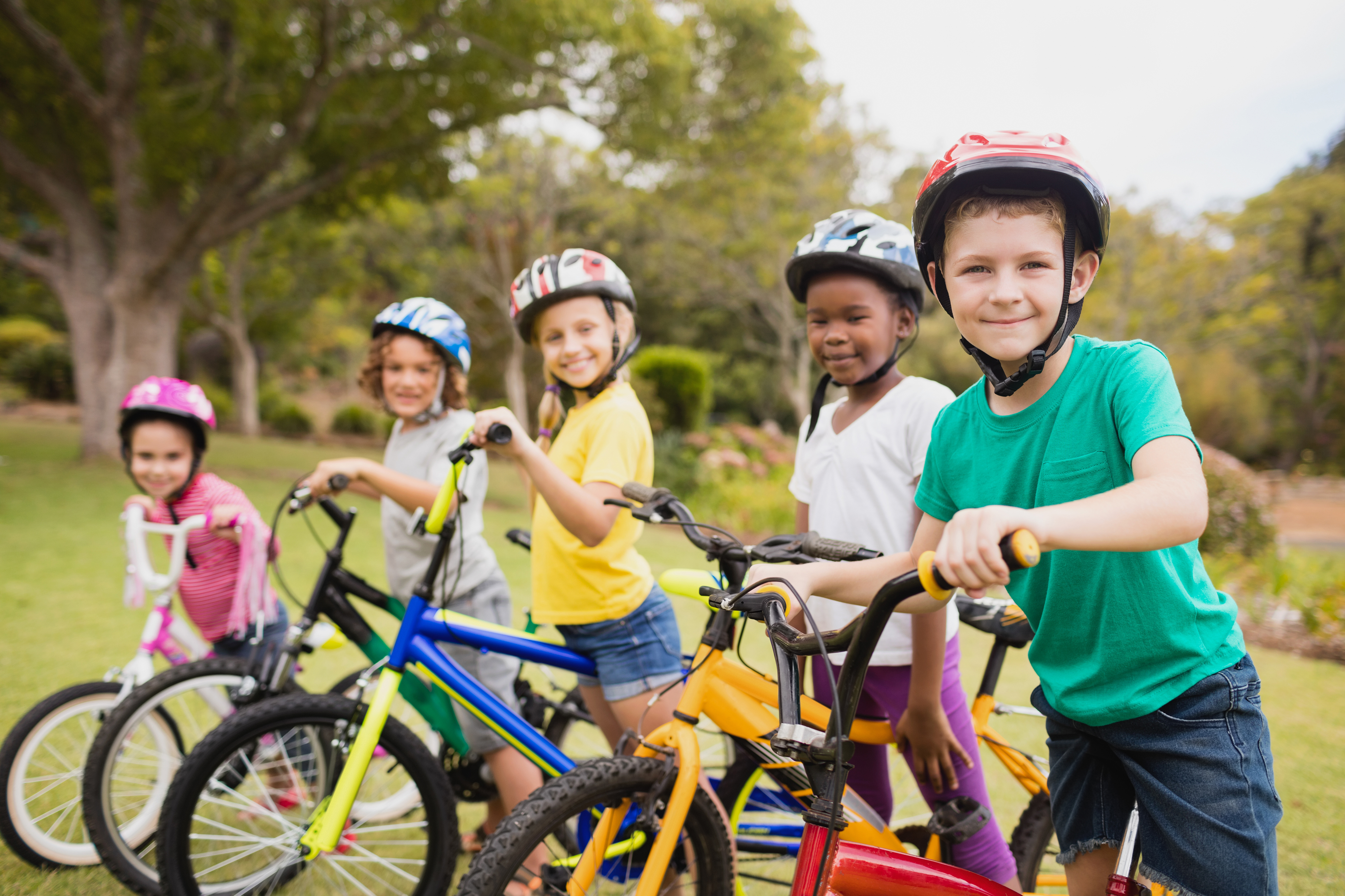 A group of children on bicycles, smiling at the camera.