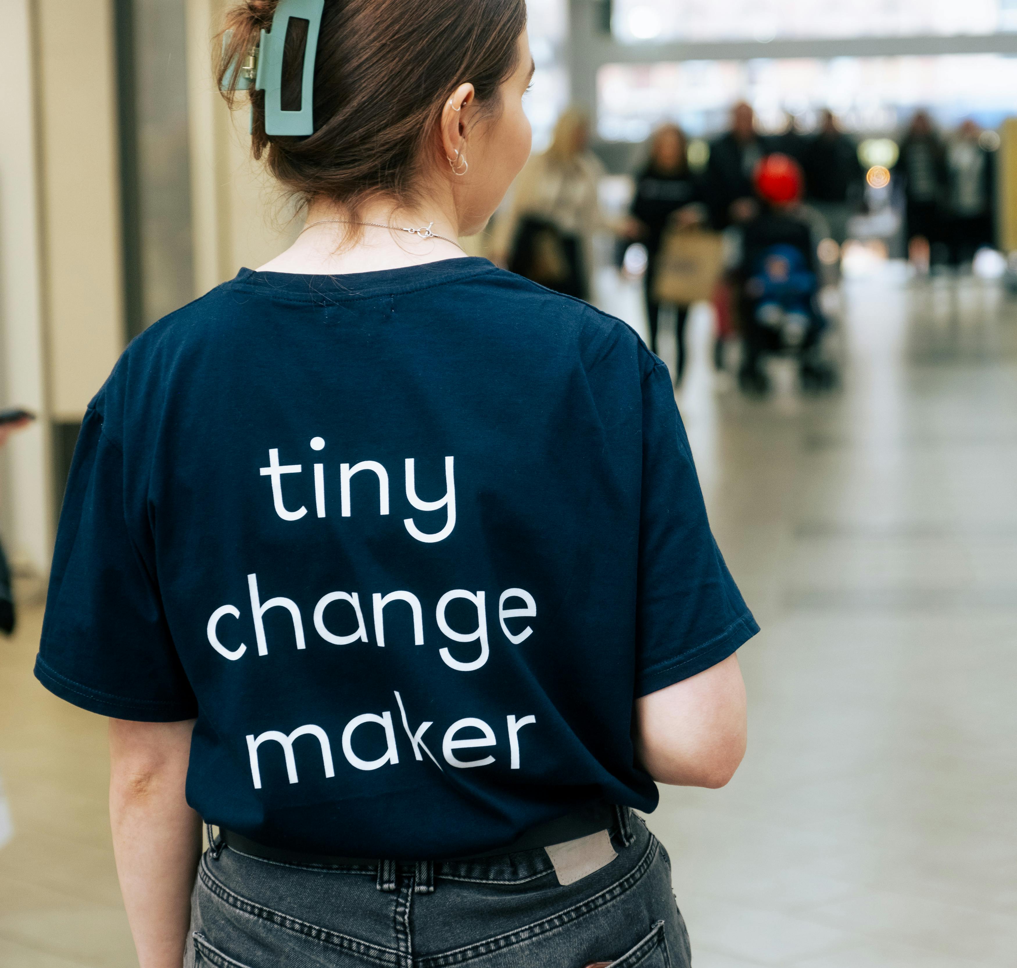 close-up on person wearing a t-shirt that reads tiny change maker on the back